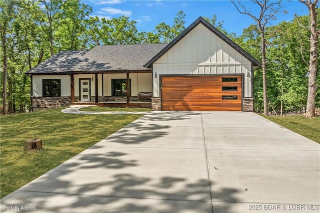 55 Turn Bridge Ln, Porto Cima, MO 65079 - view of front of house featuring stone siding, a garage, a front lawn, and driveway