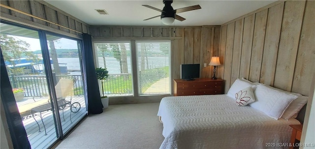 44 Port Bagnell Rd, Eldon, MO 65026 - carpeted bedroom featuring access to exterior, multiple windows, ceiling fan, and wood walls