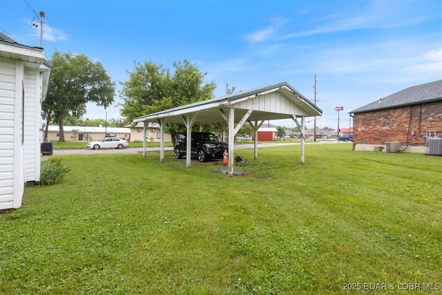 413 E 3rd St, Eldon, MO 65026 - view of green lawn with central AC and a carport
