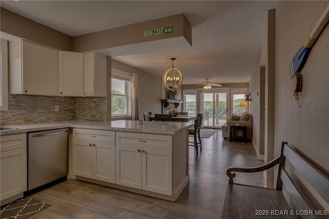 28 Wheel House Cir Unit A-4, Four Seasons, MO 65049 - kitchen featuring dishwasher, a textured ceiling, healthy amount of natural light, a peninsula, and backsplash