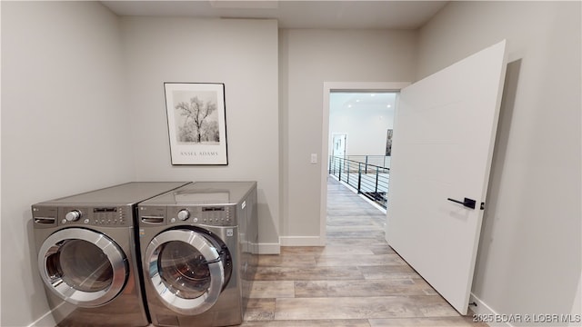 481 Comanche Rd, Lake Ozark, MO 65049 - laundry area with separate washer and dryer, light wood-type flooring, and baseboards