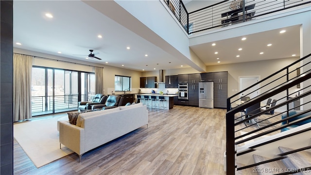 481 Comanche Rd, Lake Ozark, MO 65049 - living area with a ceiling fan, stairway, recessed lighting, light wood-style flooring, and a high ceiling