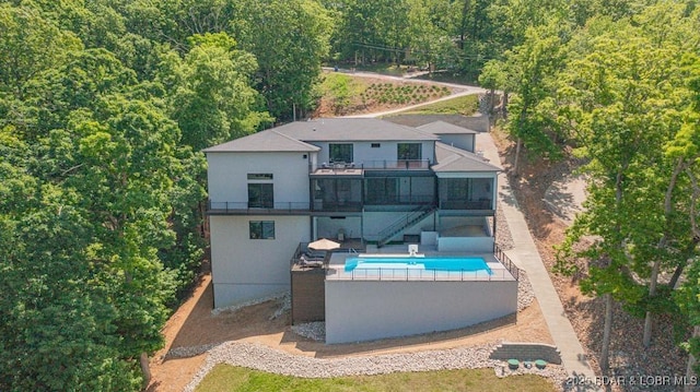 481 Comanche Rd, Lake Ozark, MO 65049 - back of house with stairway, a balcony, an outdoor pool, a patio area, and stucco siding