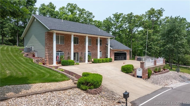 149 Snead Cir, Lake Ozark, MO 65049 - neoclassical / greek revival house with driveway, central air condition unit, a front lawn, roof with shingles, and a garage