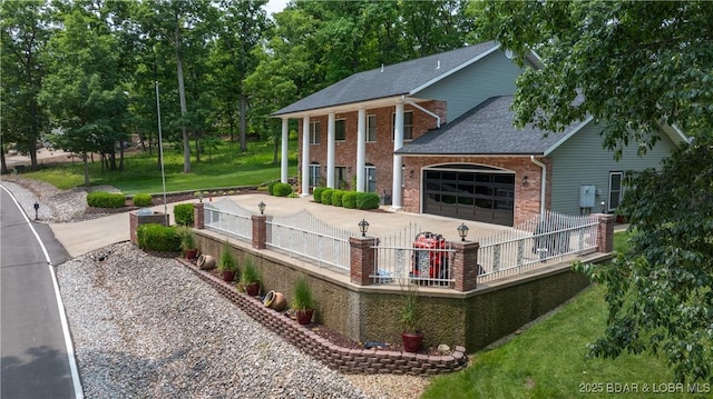 149 Snead Cir, Lake Ozark, MO 65049 - back of house with brick siding, an attached garage, a shingled roof, and driveway
