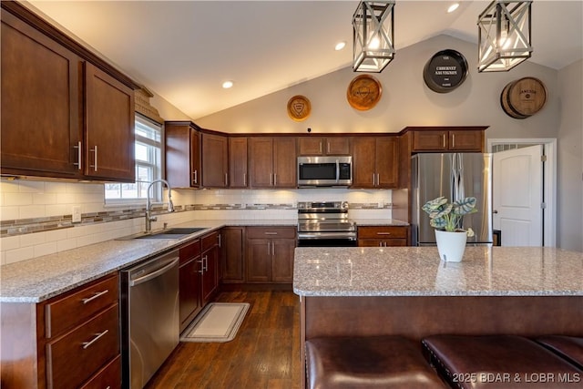 4715 Inlet Ln, Osage Beach, MO 65065 - kitchen with stainless steel appliances, a sink, vaulted ceiling, dark wood-style floors, and light stone counters