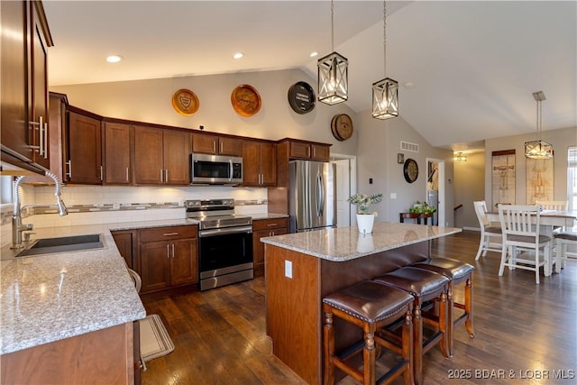 4715 Inlet Ln, Osage Beach, MO 65065 - kitchen with stainless steel appliances, a sink, high vaulted ceiling, a center island, and light stone counters