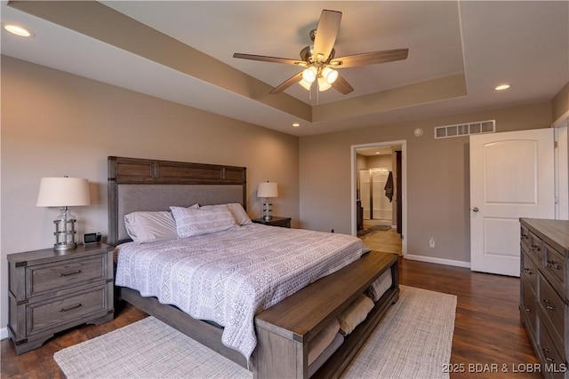 4715 Inlet Ln, Osage Beach, MO 65065 - bedroom featuring a raised ceiling, baseboards, dark wood-style floors, recessed lighting, and connected bathroom