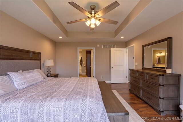 4715 Inlet Ln, Osage Beach, MO 65065 - bedroom with dark wood finished floors, recessed lighting, a tray ceiling, baseboards, and ensuite bathroom