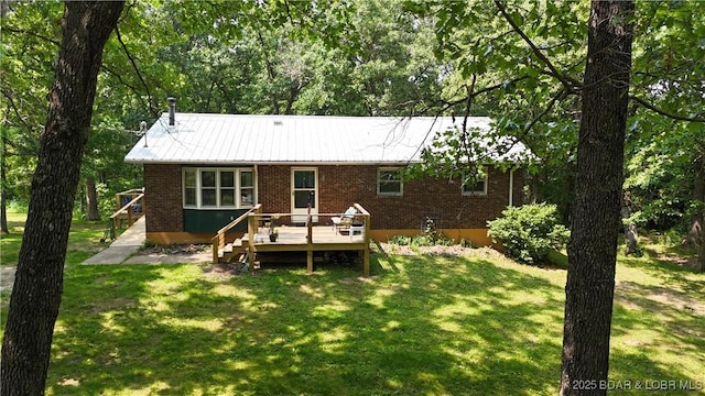 13 Bunker Rd, Eldon, MO 65026 - back of house featuring brick siding, a wooden deck, a lawn, and metal roof