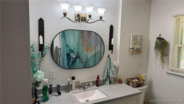 13 Bunker Rd, Eldon, MO 65026 - bathroom featuring toilet, a chandelier, vanity, healthy amount of natural light, and a textured wall