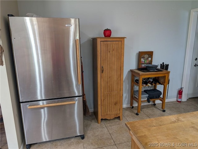 1001 Ha Ha Tonka Rd, Camdenton, MO 65020 - kitchen featuring freestanding refrigerator, light tile patterned floors, and baseboards