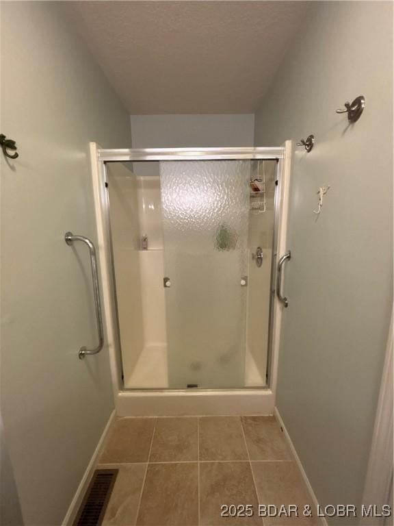 1001 Ha Ha Tonka Rd, Camdenton, MO 65020 - full bath with a stall shower, tile patterned floors, and baseboards