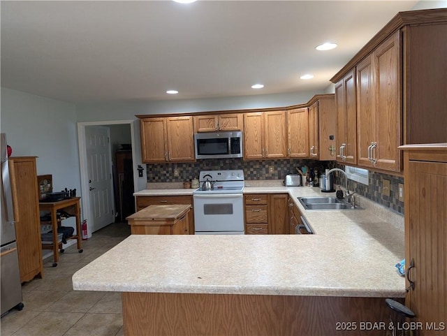 1001 Ha Ha Tonka Rd, Camdenton, MO 65020 - kitchen featuring appliances with stainless steel finishes, a sink, brown cabinets, light countertops, and recessed lighting