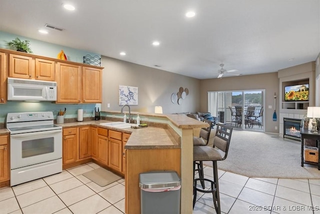 1181 Jeffries Rd Unit B107, Osage Beach, MO 65065 - kitchen with white appliances, a sink, open floor plan, a breakfast bar area, and a peninsula