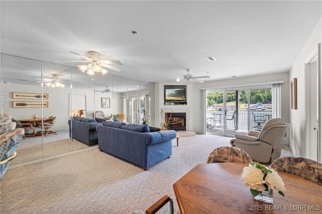 335 Vision Dr Unit 2B, Camdenton, MO 65020 - carpeted living room with ceiling fan and a warm lit fireplace