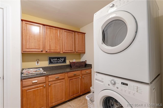 915 Bear Cave Way, Camdenton, MO 65020 - laundry room featuring stacked washer / drying machine, cabinet space, and light tile patterned flooring