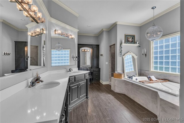 5938 N Chatham Ave, Kansas City, MO 64151 - full bathroom with a chandelier, plenty of natural light, double vanity, a garden tub, and crown molding