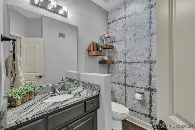 5938 N Chatham Ave, Kansas City, MO 64151 - bathroom with vanity, toilet, and wood finished floors