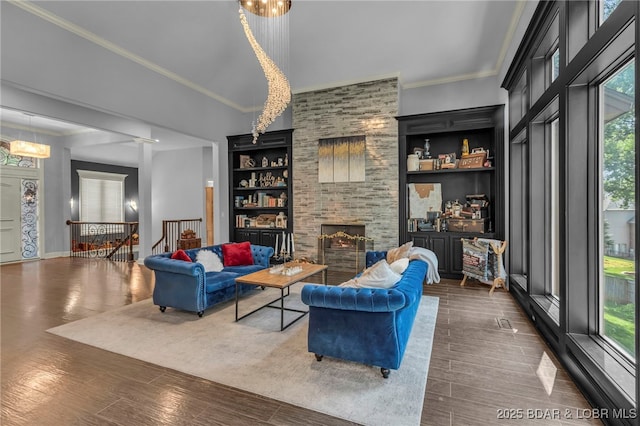 5938 N Chatham Ave, Kansas City, MO 64151 - living area with plenty of natural light, a large fireplace, wood finished floors, and ornamental molding