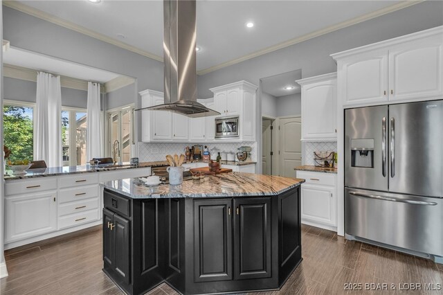 5938 N Chatham Ave, Kansas City, MO 64151 - kitchen featuring appliances with stainless steel finishes, island exhaust hood, dark cabinetry, white cabinets, and a center island