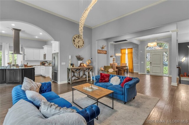 5938 N Chatham Ave, Kansas City, MO 64151 - living room featuring ornamental molding, wood finished floors, baseboards, arched walkways, and ornate columns