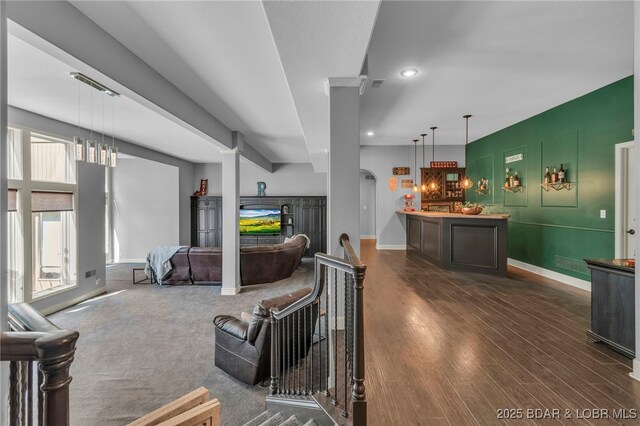 5938 N Chatham Ave, Kansas City, MO 64151 - living room featuring dark wood finished floors, baseboards, arched walkways, and recessed lighting