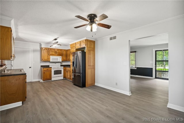 107 Haynes St, Eldon, MO 65026 - kitchen featuring white appliances, a sink, wood finished floors, dark countertops, and baseboards