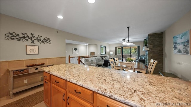 611 Lazy Days Rd Unit W1, Osage Beach, MO 65065 - kitchen with ceiling fan, light stone countertops, open floor plan, brown cabinetry, and recessed lighting