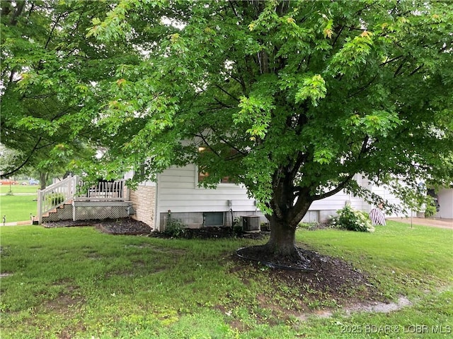 301 Burke St, Versailles, MO 65084 - view of grassy yard with central AC unit and a deck