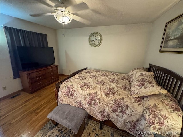 104 Tower View Dr, Versailles, MO 65084 - bedroom with wood finished floors, a textured ceiling, a ceiling fan, and baseboards