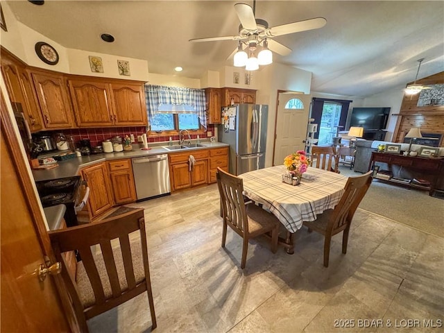 104 Tower View Dr, Versailles, MO 65084 - kitchen with appliances with stainless steel finishes, vaulted ceiling, brown cabinets, a sink, and a ceiling fan