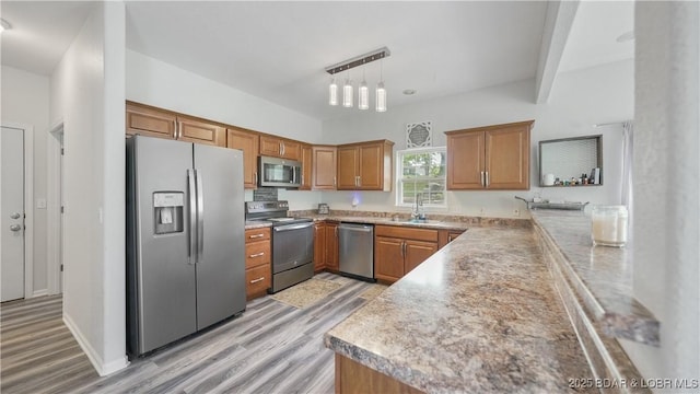 166 Joy Cir, Camdenton, MO 65020 - kitchen with stainless steel appliances, a sink, light wood-style flooring, and brown cabinets