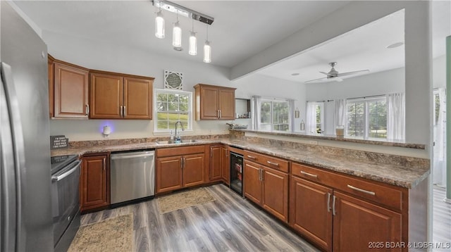 166 Joy Cir, Camdenton, MO 65020 - kitchen featuring appliances with stainless steel finishes, a peninsula, a sink, ceiling fan, and wood finished floors