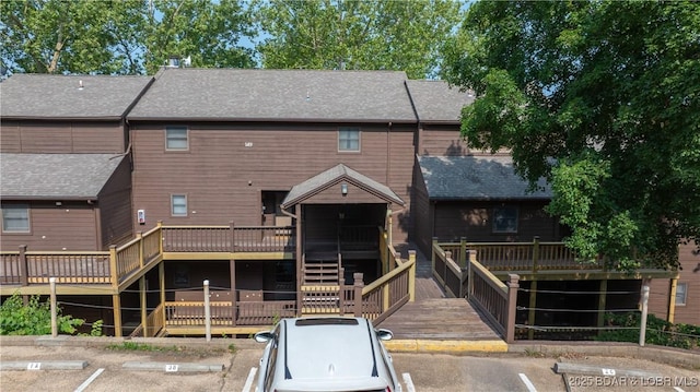 149 Sycamore Beach Rd Unit C1, Camdenton, MO 65020 - view of front of home featuring a wooden deck, uncovered parking, a shingled roof, and stairway