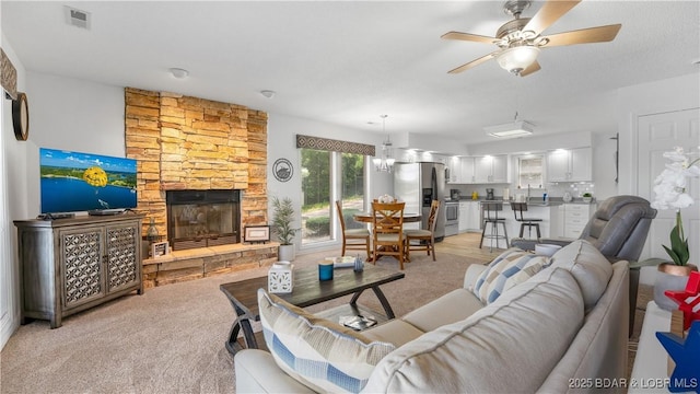149 Sycamore Beach Rd Unit C1, Camdenton, MO 65020 - living room with a ceiling fan, a fireplace, and light colored carpet