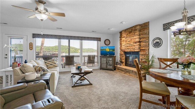 149 Sycamore Beach Rd Unit C1, Camdenton, MO 65020 - carpeted living room featuring a chandelier, ceiling fan, and a stone fireplace