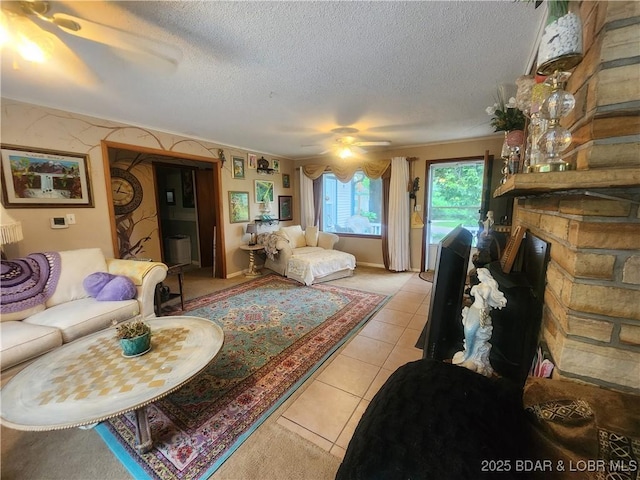 159 Tonka Shady Ln, Camdenton, MO 65020 - living room featuring a textured ceiling, a ceiling fan, light tile patterned flooring, and a stone fireplace