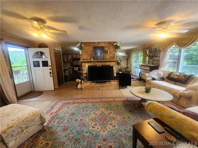 159 Tonka Shady Ln, Camdenton, MO 65020 - living room with ceiling fan, a textured ceiling, a large fireplace, and light tile patterned floors