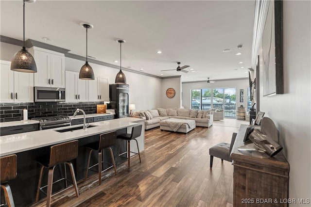 1184 Jeffries Rd Unit 312, Osage Beach, MO 65065 - kitchen with stainless steel appliances, a sink, a breakfast bar area, light countertops, and open floor plan