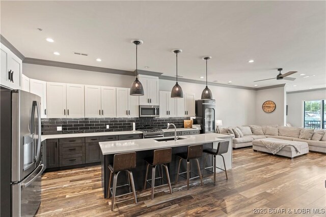 1184 Jeffries Rd Unit 312, Osage Beach, MO 65065 - kitchen with stainless steel appliances, open floor plan, a breakfast bar, light countertops, and crown molding