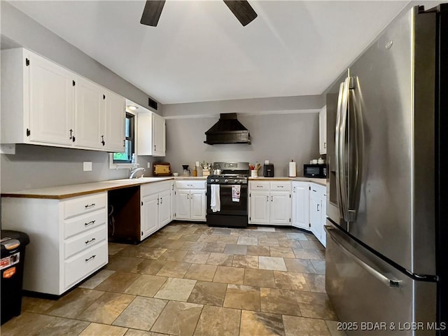 75 Central Hill Rd, Eldon, MO 65026 - kitchen with stainless steel appliances, wall chimney range hood, stone finish floors, a ceiling fan, and light countertops
