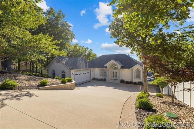 549 Cedar Rd, Lake Ozark, MO 65049 - view of front of home with a garage, concrete driveway, and stucco siding