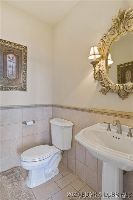 549 Cedar Rd, Lake Ozark, MO 65049 - half bath with toilet, wainscoting, tile patterned floors, tile walls, and a sink