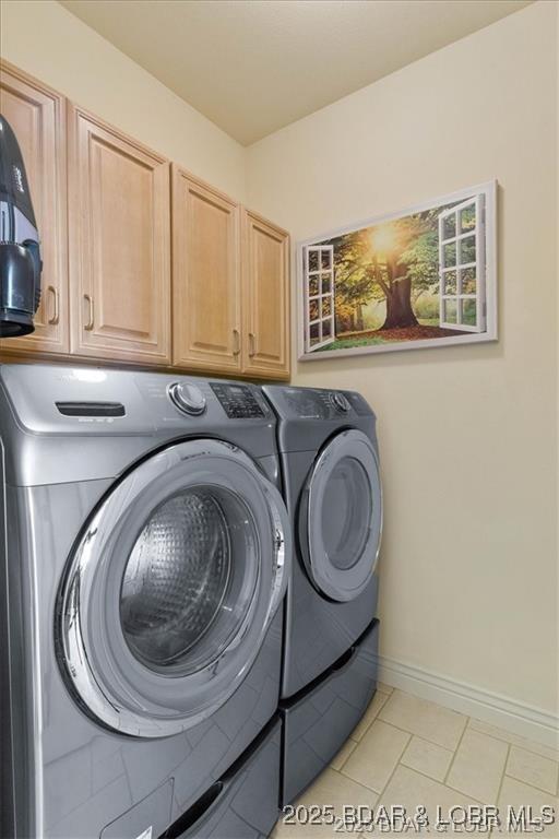 549 Cedar Rd, Lake Ozark, MO 65049 - laundry room featuring cabinet space, washer and dryer, light tile patterned flooring, and baseboards