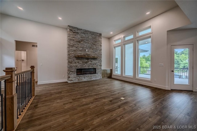 80 Ledgestone Estates Ct, Sunrise Beach, MO 65079 - unfurnished living room featuring dark wood-type flooring, healthy amount of natural light, a stone fireplace, a high ceiling, and recessed lighting