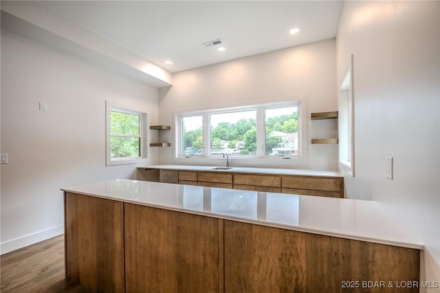 80 Ledgestone Estates Ct, Sunrise Beach, MO 65079 - kitchen with open shelves, brown cabinetry, wood finished floors, light countertops, and a peninsula