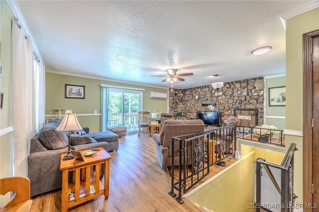 15852 Kindling Rd, Eldridge, MO 65463 - living room with ornamental molding, a textured ceiling, wood finished floors, ceiling fan, and an AC wall unit