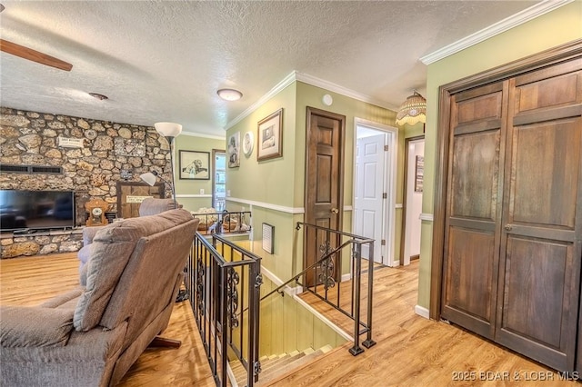 15852 Kindling Rd, Eldridge, MO 65463 - living room with a textured ceiling, light wood-style flooring, and crown molding