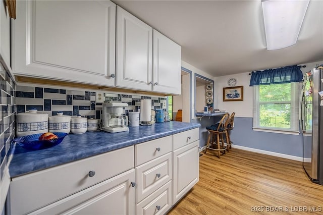 15852 Kindling Rd, Eldridge, MO 65463 - kitchen featuring baseboards, white cabinetry, dark countertops, and light wood-style flooring